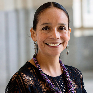 Schar School of Policy and Government Professor, Guadalupe Correa-Cabrera stands and smiles for a photo.